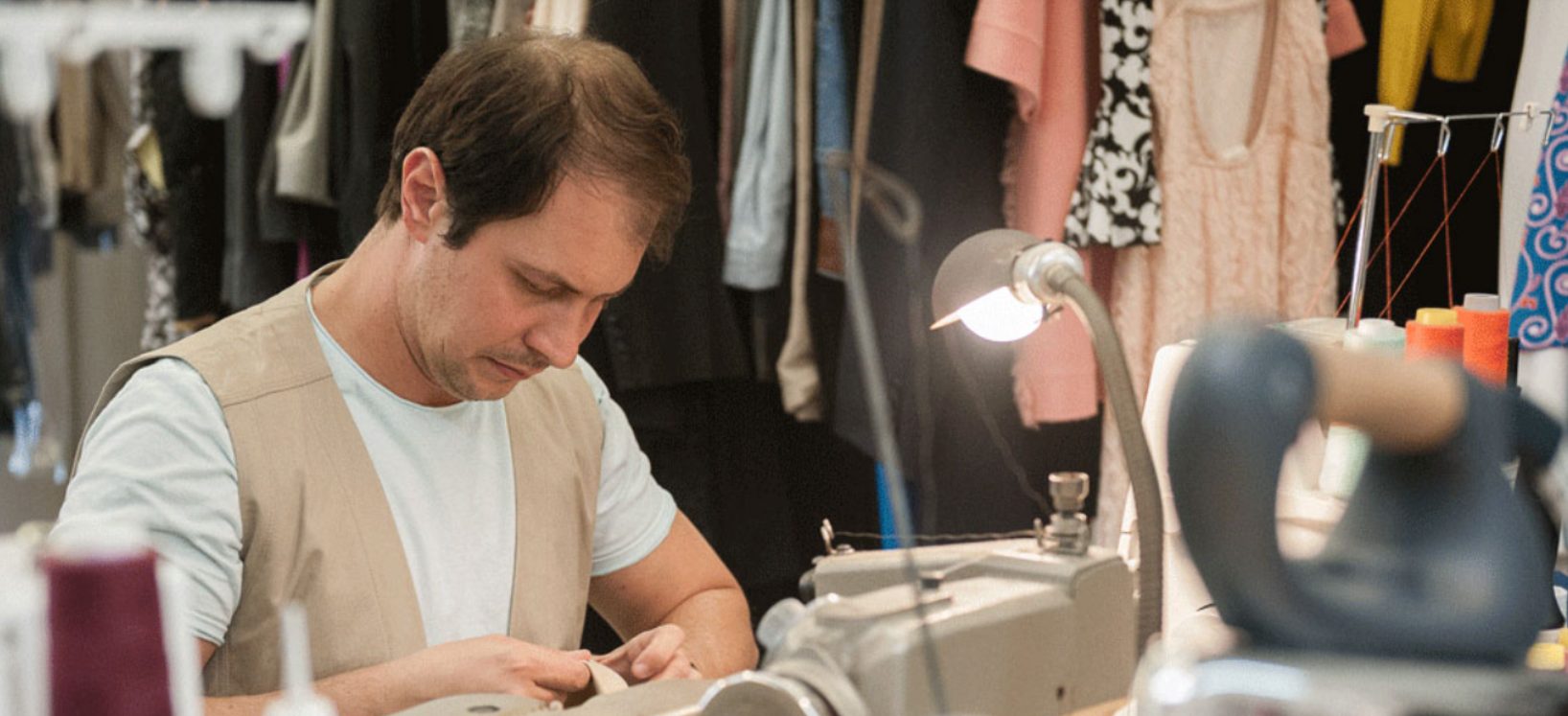 Benjamin Lup working among garments in the shop